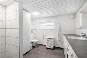 a white bathroom with a toilet and a sink at 0194-Romo-Rabjergvej-76 in Høm