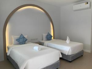 two beds sitting next to each other in a room at Thong Prachok Hotel in Sakon Nakhon