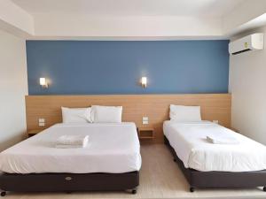two beds in a bedroom with a blue wall at Ceniq Hotel in Sathani Nakhon Lampang +276 photos