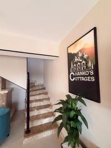 a staircase with a sign on the wall and a plant at Chanko's Cottages in Tsemi