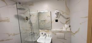 a bathroom with a glass shower and a sink at Penzion Tavcar in Ljubljana +41 photos