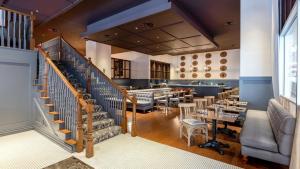 a restaurant with a staircase and tables and chairs at CozySuites at LTV in Dallas +4 photos