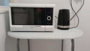 a microwave sitting on top of a white table at Self check-in Apartament Poznań Marcelin Lotnisko Ławica Szpitale Uczelnie in Poznań