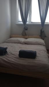 a bed with a pillow on top of it with a window at Self check-in Apartament Poznań Marcelin Lotnisko Ławica Szpitale Uczelnie in Poznań