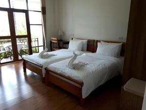 a bedroom with two beds with white birds on them at Gin's Greenery Resort in Ban Hua Wiang
