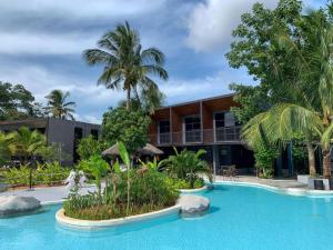 a resort with a pool in front of a building at Warehouse18 Pool Cafe Resort in Don Sak