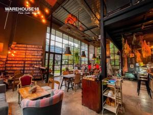a large room with tables and chairs in a library at Warehouse18 Pool Cafe Resort in Don Sak