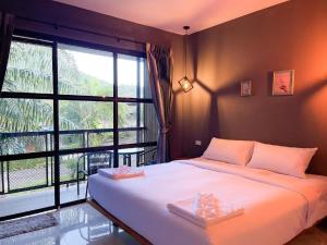 a bedroom with a bed and a large window at Warehouse18 Pool Cafe Resort in Don Sak +116 photos
