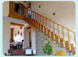 a staircase in a living room with a stone wall at Вовча хижа in Khmelnytskyi