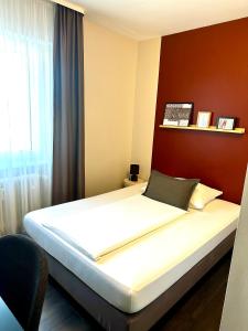 a large bed in a room with a window at Hotel Friedrichstraße in Lampertheim +30 photos