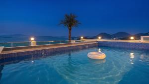 a swimming pool at night with a raft in the water at Yeosu Hemiswi SPA Pension in Yeosu +12 photos