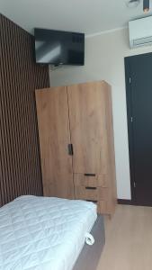 a bedroom with a bed and a wooden cabinet at Tomberg 