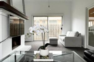 a living room with a couch and a table at Beach Rd Kids & Pet Friendly Free Parking in Mordialloc