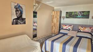 a bedroom with a bed and a picture of a woman at VACANCES PAISIBLES - Option Menu & petit-déjeuners payant in Saint-Paul