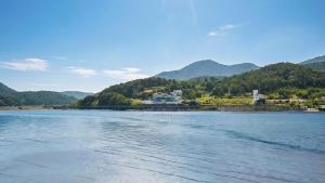 a large body of water with a building in the distance at Yeosu Hwangto Pension in Yeosu