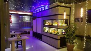a room with purple lights and a table and a counter at RungRoj Panich Hotel in Ban Bang Saen (1)