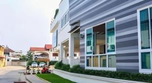 a facade of a building with cars parked on the street at The Grace Residence in Surin