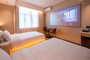 a hotel room with two beds and a flat screen tv at H Life Hotel in Shenzhen +287 photos