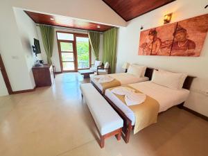 a bedroom with two beds and a living room at vainika wild sigiriya in Sigiriya +33 photos