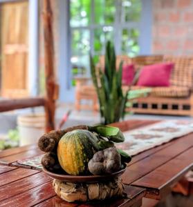 a melon on a plate on a wooden table at Alkebulan cottages in Uru