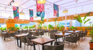 a restaurant with tables and chairs and plants at Rhyme Hotel - Hitech City in Hyderabad