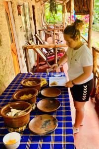a woman standing in front of a table with food at Alkebulan cottages in Uru
