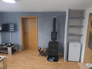 a living room with a stove in the corner at Planinska Kuca "KABLAR" Jahorina in Pale