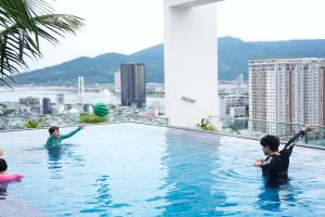 a group of people playing in a swimming pool at Centre Point Da Nang City Hotel - Afternoon Tea Inclusive in Danang