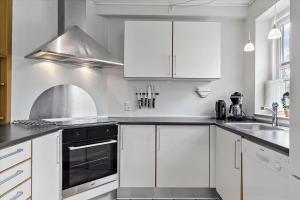a kitchen with white cabinets and a sink at 0045-Romo-Thadesvej-13 in Høm