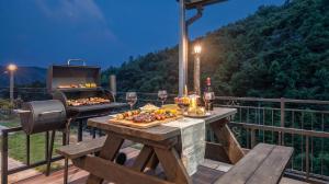 a table with food and wine and a grill on a deck at Gapyeong Nomadrium poolvilla Pension in Gapyeong