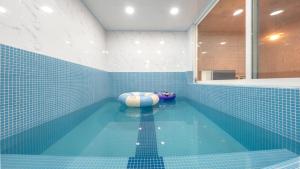 a blue tiled bathroom with a swimming pool at Gapyeong Nomadrium poolvilla Pension in Gapyeong