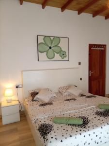 a bedroom with a bed with a green flower picture on the wall at Skye in Hortons in Pattipola