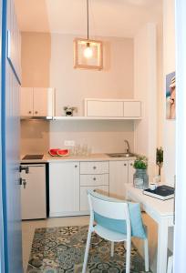 une cuisine avec une table blanche et une chaise bleue dans l'établissement Astropalia Luxury Studios, à Astypalée