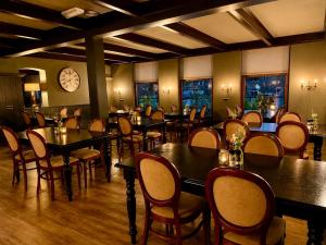 a restaurant with tables and chairs and a clock on the wall at Hotel Restaurant 't Ronde Loegh in Winschoten