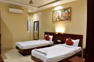 a hotel room with two beds and a painting on the wall at Sangam Hotel in Kiul +14 photos