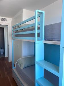 a bunk bed with a blue ladder in a room at Beachfront with pool and great views in Mataró +32 photos