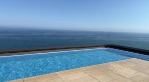 a swimming pool with the ocean in the background at Beachfront with pool and great views in Mataró