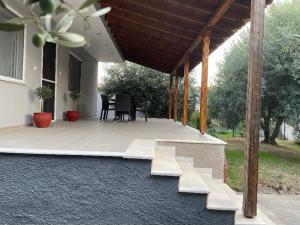 a covered patio with a table and chairs on it at Betty's Seaside Olive House in Ofrínion