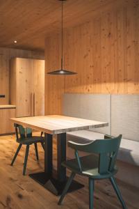 a dining room with a table and two chairs at Arthotel Gratschwirt in Dobbiaco