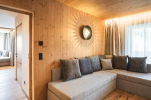 a living room with a couch and a mirror on the wall at Arthotel Gratschwirt in Dobbiaco +79 photos