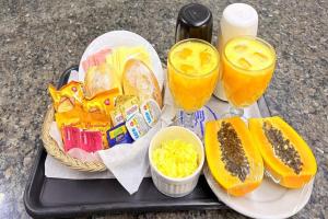 a tray with a basket of food and two glasses of juice at Style Hotel ( Adults Only) in São Paulo