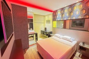 a bedroom with a bed and a bathroom with a television at Style Hotel ( Adults Only) in São Paulo