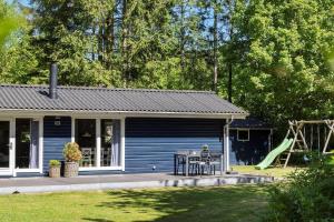 a blue house with a table and a playground at 0664-Toftlund-Sydmarken-83 in Toftlund