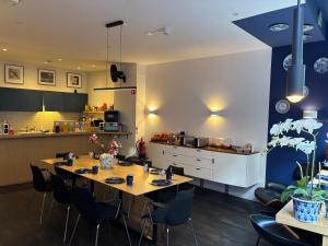 a dining room with a table and a kitchen at Amistad hotel in Amsterdam