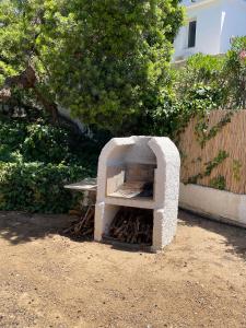 a stone oven in a yard with a bench at Villino Sicaru' in Simius