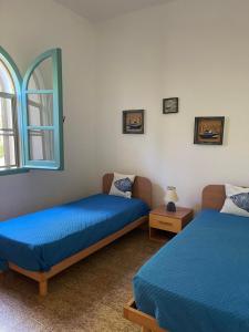 a bedroom with two beds and a window at Villino Sicaru' in Simius