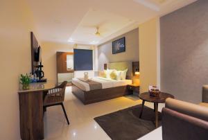 a hotel room with a bed and a desk at Rhyme Hotel - Hitech City in Hyderabad +42 photos