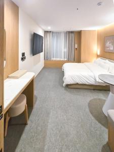 a hotel room with a large bed and a television at Mare Suite Hotel in Incheon