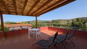 a patio with a table and chairs on a roof at Agrialbergo Capalbio La Sugherella - Hotel Il Cipresso in Capalbio