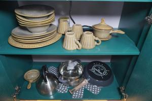 a shelf with plates and utensils in a cabinet at Pequeño Refugio in Ticul